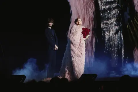 Céline Dion, un bouquet de roses rouges dans les bras, sur la scène de la Plenitude Arena